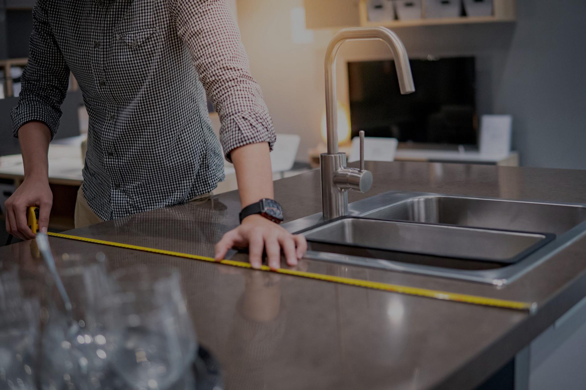 Expert taking precise countertop measurement with solid surface detail